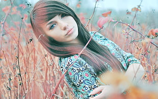 woman wearing white and multicolored top on the green leaf plant field